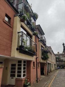 a building with potted plants and balconies on a street at West End & EICC with Parking in Edinburgh