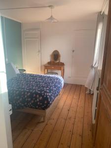 a bedroom with a bed and a wooden floor at Maison de ville au bord de la rivière ! in Beauvais