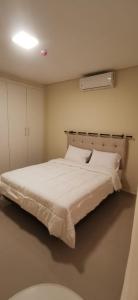 1 dormitorio con 1 cama blanca grande en una habitación en Apart hotel Florida, en Ciudad del Este