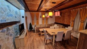een eetkamer met een tafel en een bank bij Ski House in Kopaonik