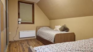 een slaapkamer met twee bedden en een raam bij Ski House in Kopaonik
