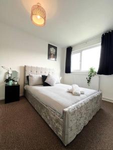 a bedroom with a large bed and a window at 3 Bedroom House With Free Parking in Chatham