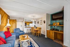 een woonkamer met een blauwe bank en een tafel bij Pinnacle C09 in Killington
