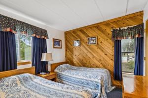 een slaapkamer met 2 bedden en een houten muur bij Pinnacle C09 in Killington