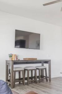 una mesa con tres taburetes y un televisor en una pared en Shoreside 4b/4b walkout retreat with perfect sand, en Ottertail
