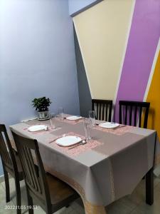 a table with chairs and a white table cloth on it at Yuyu homestay in Johor Bahru