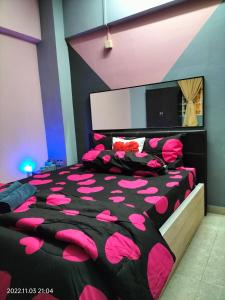 1 dormitorio con cama cubierta de almohadas rosas en Yuyu homestay en Johor Bahru