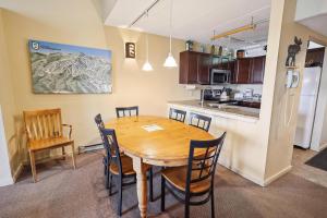 a kitchen and dining room with a wooden table and chairs at Pinnacle A23 in Killington