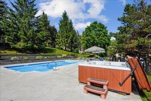 a hot tub with a chair next to a swimming pool at Pinnacle A23 in Killington