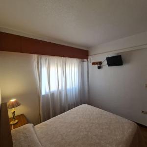 1 dormitorio con 1 cama y TV en la pared en Precioso apartamento en Cullera, con piscina junto a la playa, en Cullera