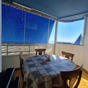 comedor con mesa y sillas y ventana grande en Precioso apartamento en Cullera, con piscina junto a la playa, en Cullera