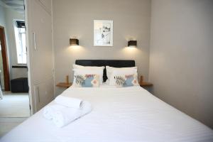 1 dormitorio con 1 cama blanca y 2 almohadas en Unhotel - Charmoso Studio no Leblon, entre a Praia e Rua Dias Ferreira, en Río de Janeiro