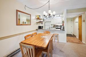 uma cozinha e sala de jantar com uma mesa de madeira e cadeiras em Pinnacle E07 em Killington