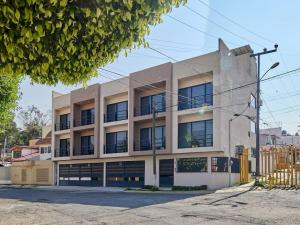 un edificio blanco con ventanas en una calle en S03 DE CASONA TRES SUITES PREMIUM INCREÍBLES ITESM CEM S03, en Ciudad de México