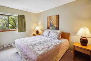 a bedroom with a bed and two lamps and a window at Pinnacle E07 in Killington +11 photos