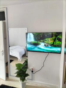 a flat screen tv hanging on a wall at Johari Suites and Shared Studio Westlands in Nairobi