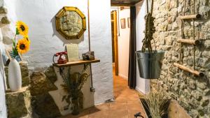 a hallway with a stone wall and a mirror at Cal Belló Casa rural in Lleida
