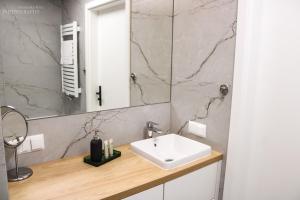 La salle de bains est pourvue d'un lavabo et d'un miroir. dans l'établissement D Apartments Centrum Prowiantowa, à Białystok