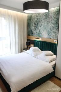 um quarto com 2 camas brancas e uma grande janela em D Apartments Centrum Prowiantowa em Bialystok