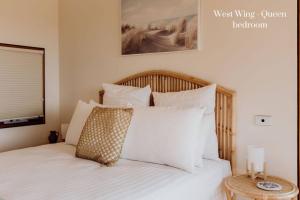 1 dormitorio con 1 cama con sábanas y almohadas blancas en Miramar Beach House, en Seymour