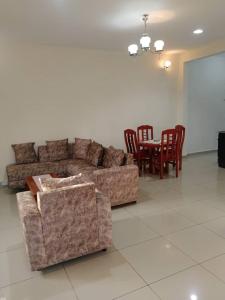- un salon avec un canapé, une table et des chaises dans l'établissement Résidence Rosalie, à Yaoundé