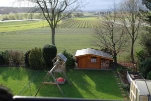 a small wooden cabin with a ladder and a playground at Gästezimmer Anita in Schwabach