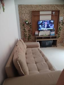 a living room with a couch and a tv at Casa temporada ilheus in Ilhéus