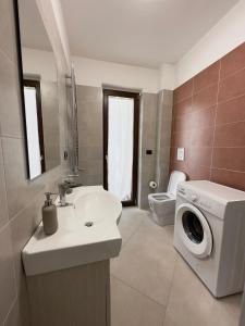 a bathroom with a sink and a washing machine at Arya temporary home - Naples- Pompei- Amalfi Coast in San Vitaliano  +10 photos