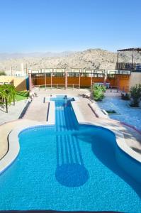 a swimming pool with blue water in the desert at Jabal Al Akhdar Grand Hotel in Jabal Al Akhdar