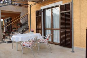 einen Tisch und Stühle auf einem Balkon mit Fenster in der Unterkunft Lily's lovely apartments in Fažana