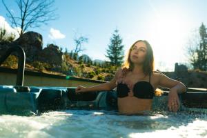 a woman in a bathing suit in a hot tub at Villa T Apartments & SPA in Zakopane