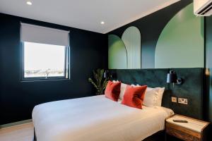 Un dormitorio con una gran cama blanca con almohadas rojas. en Your Apartment I Milton Keynes, en Milton Keynes