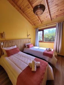 a bedroom with two beds and a window at Ruca Nel in El Calafate