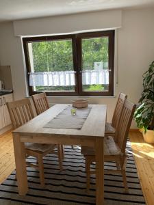 a wooden table and chairs in a room with a window at Ferienwohnung Am Elzbach in Monreal