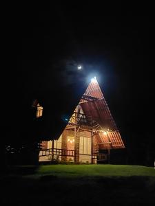 a house with a pointed roof at night at Cabaña El Viejo del Monte in Venecia