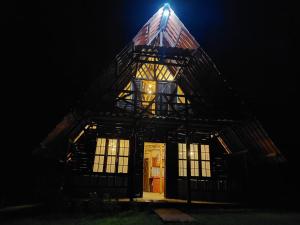 abered house with a lit up roof at night at Cabaña El Viejo del Monte in Venecia