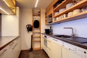 uma cozinha com armários brancos e um lavatório em Astoria 341 em Verbier