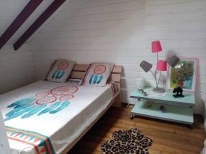 1 dormitorio con 1 cama y 1 mesa con lámpara en Aux charmes du Saut d'Eau, en Saint-Claude