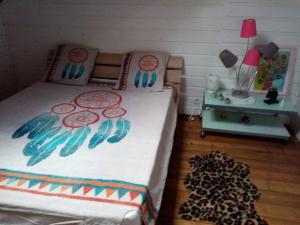 a bedroom with a bed with a bedspread with fish on it at Aux charmes du Saut d'Eau in Saint-Claude