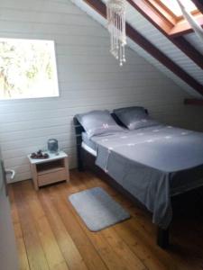 ein Schlafzimmer mit einem Bett und einem Tisch mit einem Fenster in der Unterkunft Aux charmes du Saut d'Eau in Saint-Claude