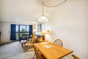 a living room with a dining room table and chairs at Pinnacle A11 in Killington