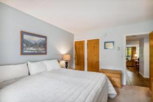 a bedroom with a large white bed in a room at Pinnacle E05 in Killington +8 photos