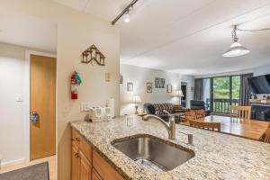 a kitchen with a sink and a living room at Pinnacle E10 in Killington