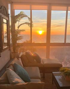 uma sala de estar com um pôr-do-sol visto através de uma janela em Quiero Cádiz em Cádiz
