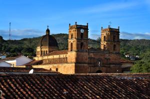 an old building with two towers with a clock on it at Santa Sofia Casa Boutique in Barichara