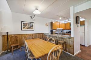 a kitchen and dining room with a wooden table and chairs at Pinnacle E25 in Killington