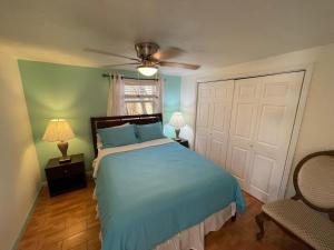 um quarto com uma cama azul e uma ventoinha de tecto em 4BR Downtown House Near Beach, Pet Friendly em West Palm Beach