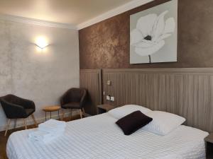 pokój hotelowy z łóżkiem i 2 krzesłami w obiekcie Hôtel Influences La Bresse w mieście La Bresse