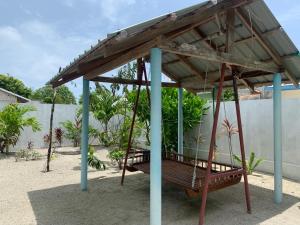 a swing seat in a playground with a roof at Arrow in Vashafaru