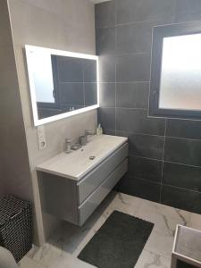 a bathroom with a white sink and a mirror at magnifique villa avec piscine et spa in Merville